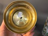 a person holding a gold cup with a sticker on it
