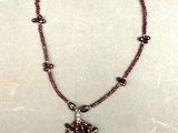un gros plan d'un collier orné de perles sur un fond blanc