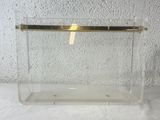 a clear box with a gold handle on a table