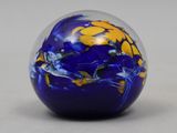 a blue and yellow marble ball on a white surface