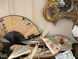 a table with a bunch of fan and other items on it