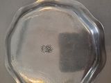 a silver plate with a flower on it on a table