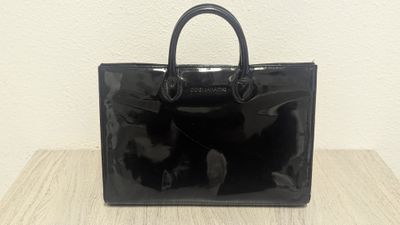 a black handbag sitting on top of a wooden table
