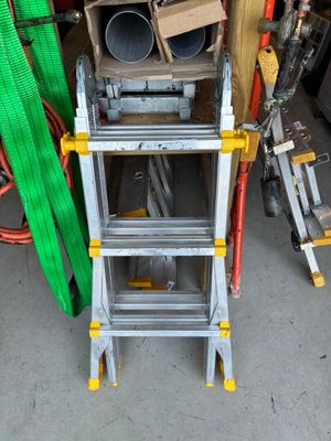 une échelle posée à côté d'un tas d'outils
