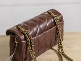 a brown leather purse sitting on top of a wooden table