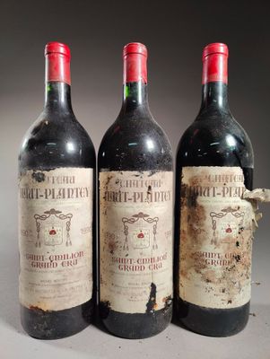 trois bouteilles de vin rouge posées côte à côte sur une table