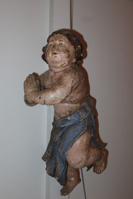a small statue of a child hanging from a string