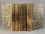 un lot de cinq livres anciens empilés les uns sur les autres