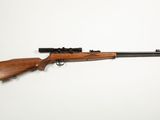 a rifle on a white background with a gun in the foreground