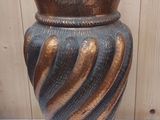 un vase marron et noir posé sur une table