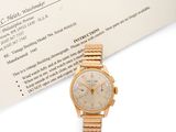 une photo d'une montre-bracelet en or posée à côté d'une carte de visite
