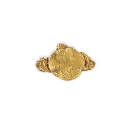 un gros plan d'une bague en or sur laquelle est gravé le visage d'une femme