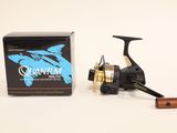 a close up of a fishing reel next to a box