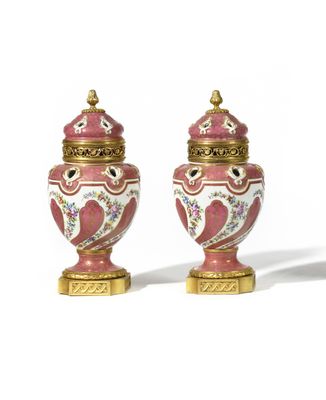 pair of pink and white vases with gold trimmings on them