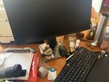 a desk with a computer, keyboard, mouse, and other items on it