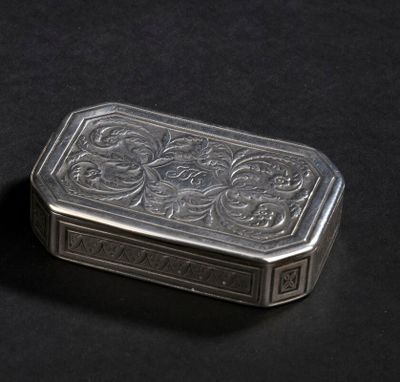une vieille boîte en argent posée sur une surface noire