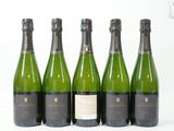 quatre bouteilles de vin sont alignées sur une surface blanche