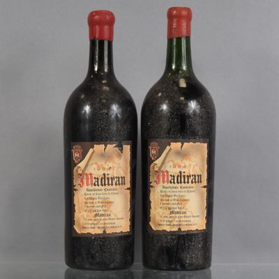 two bottles of red wine sitting on top of a glass table