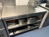 des casseroles et des poêles posées sur une étagère dans une cuisine
