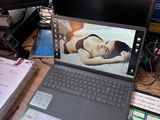 un ordinateur portable dont l'écran affiche la photo d'une femme, posé sur un bureau