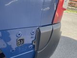 a close up of a blue van parked in a parking lot