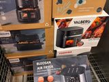Plusieurs cartons contenant des friteuses à air chaud sont empilés les uns sur les autres