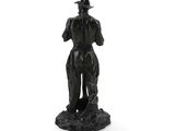 statue of a man with a hat and a cane standing on a rock