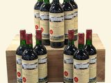 six bottles of red wine in a wooden crate on a white background