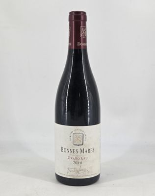 the bottle of wine is sitting on a white surface