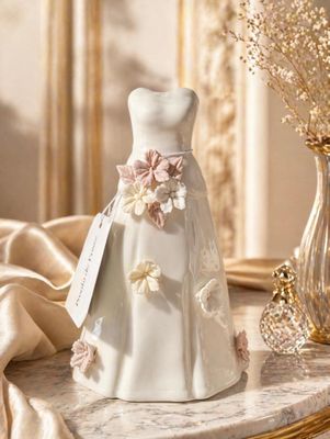 une robe de mariée posée sur une table, à côté d'un vase de fleurs