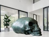 sculpture of a skull on a table in front of a large window