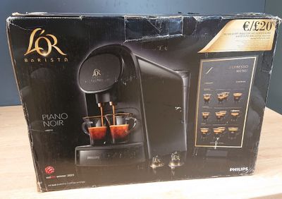 La boîte de la machine à café est ouverte sur la table.