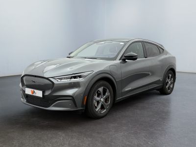Une Ford Mustang Macht 2020 grise est garée dans une pièce blanche