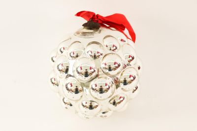 a glass ornament with a red bow on it