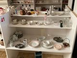 une étagère blanche sur laquelle sont posés de nombreux plats
