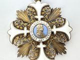 a white and gold medal with a blue picture on it