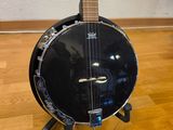 an image of a black banjo sitting on top of a hard wood floor
