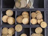 de nombreuses pièces dans un plateau, avec un sachet contenant ces pièces