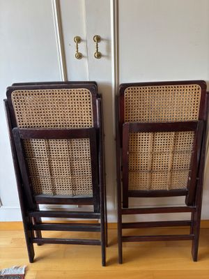 two wooden chairs sitting next to each other on top of a hard wood floor