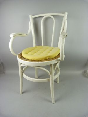 a white chair with a yellow seat pad on it