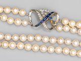 un gros plan sur un collier orné de perles et d'une broche
