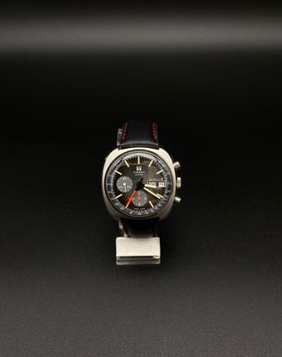 une image représentant une montre posée sur une surface noire
