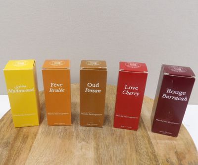 four boxes of perfume sitting on top of a wooden table