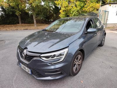 une voiture grise garée sur un parking, avec des arbres en arrière-plan