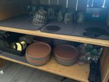 de nombreuses assiettes et tasses sur une étagère dans la cuisine