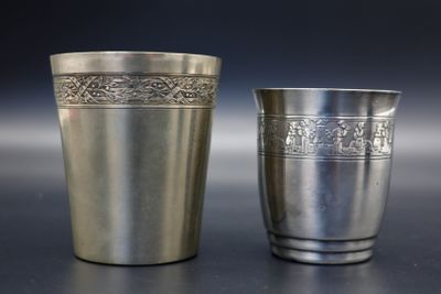 deux tasses en argent posées l'une à côté de l'autre sur une table