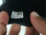 a person holding a black glove with a tag on it