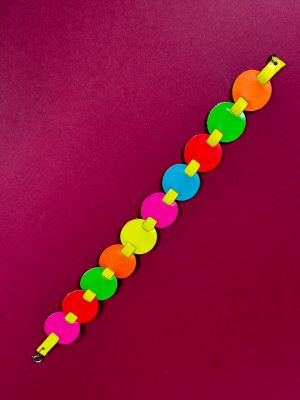 a close up of a colorful bracelet on a purple surface
