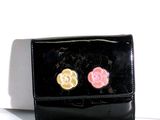 un sac à main noir orné de deux fleurs roses et jaunes