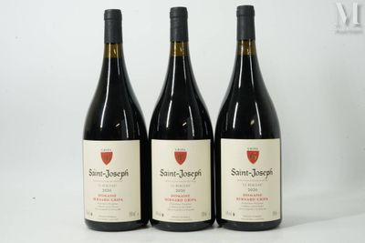 trois bouteilles de vin sont alignées sur une surface blanche